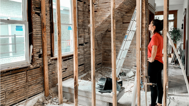 Homeowner looking at interior walls that have been taken down to the studs